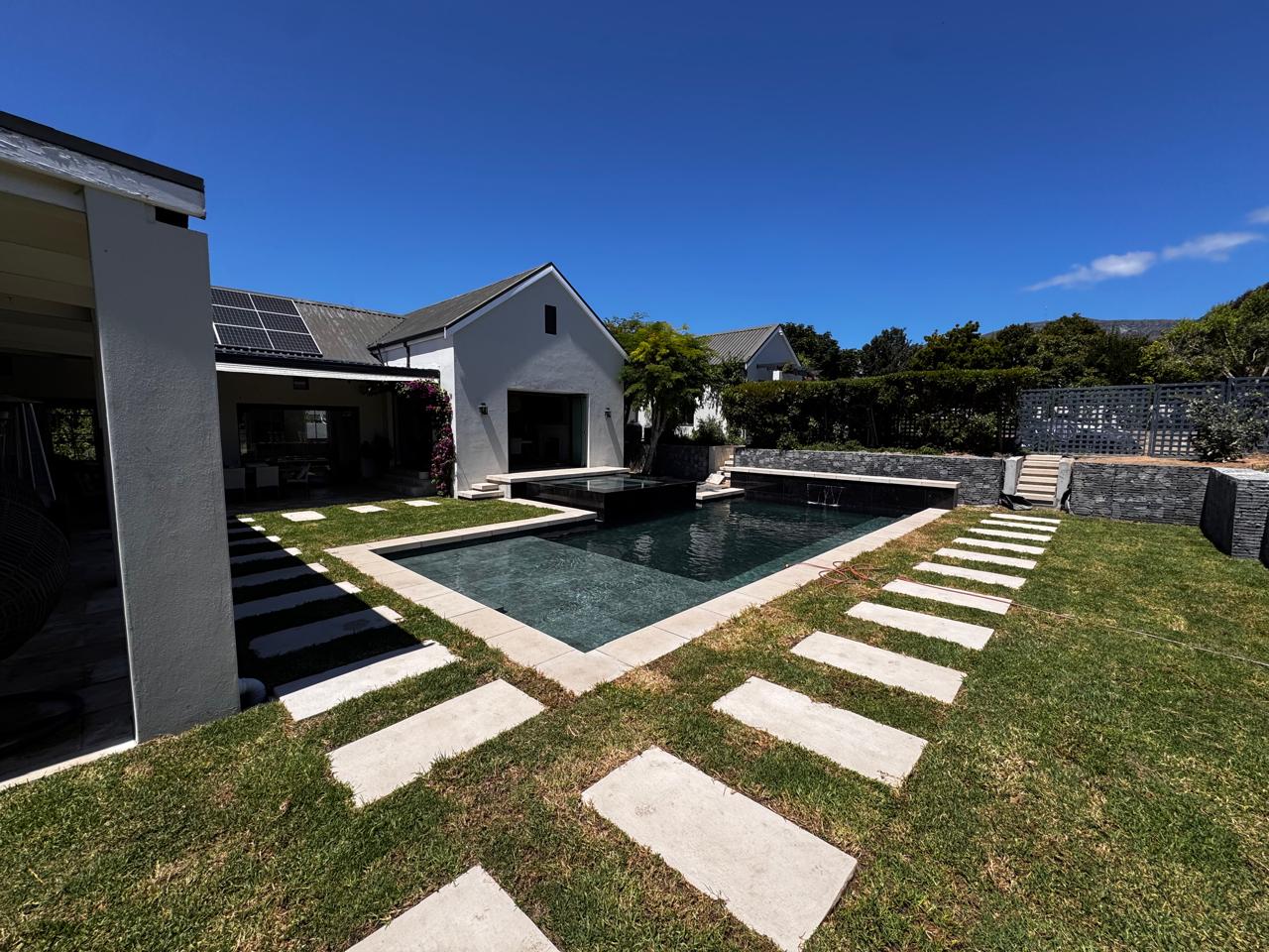 Swimming Pool Renovation with custom built spa, water feature & new paving & pool coping in Constantia, Southern Suburbs, Cape Town.